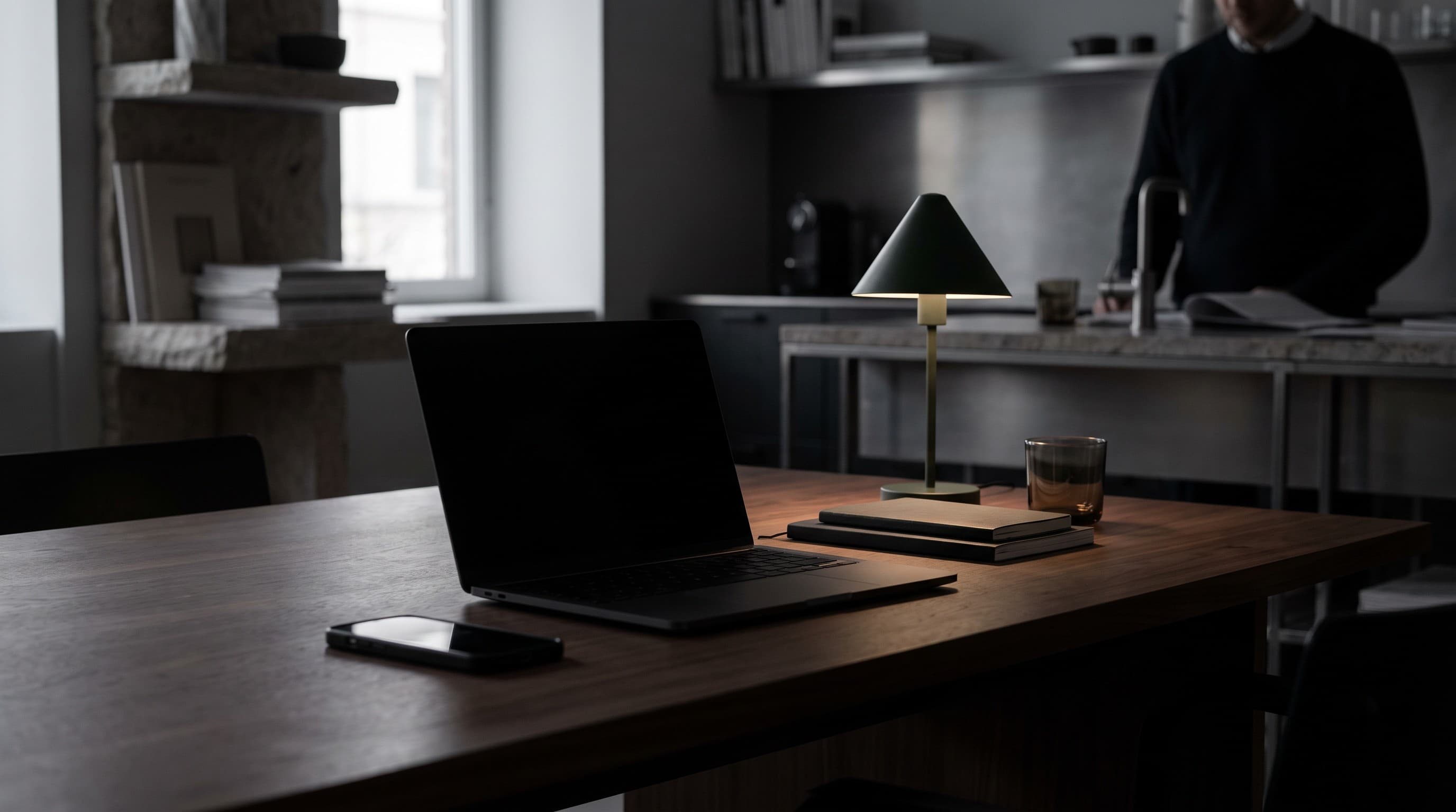 Una laptop cerrada y un teléfono sobre un escritorio tranquilo